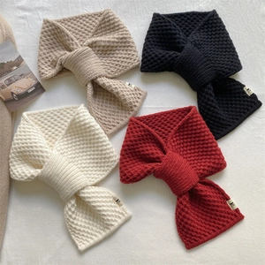 Detailed view of autumn winter knitted cross neck scarf in four classic cozy colors