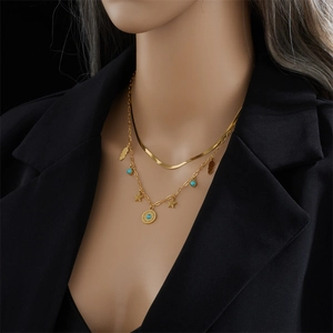 Gold double-layered necklace set featuring turquoise, star and sun disc charms on a model