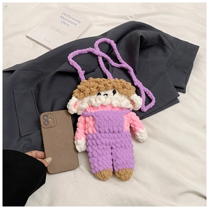 Handmade crochet cartoon doll crossbody bag shown next to a phone for size reference