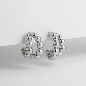Detailed view of dual-layer C-shaped silver bubble ball earrings with polished finish