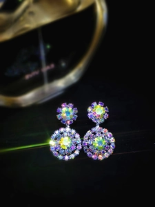 Macro detail of snowflake earrings with colorful rhinestones and a large yellow center stone
