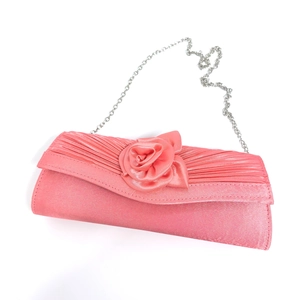Detailed macro view of pink satin evening clutch with handmade fabric rose and silver chain