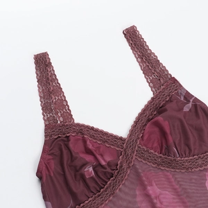 Détail du col en dentelle et du tissu mesh fleuri d'un caraco bordeaux chic