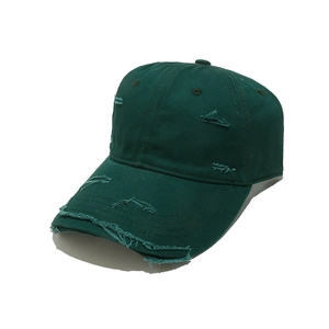 Detail shot of distressed vintage dark green baseball cap with worn-out holes and texture