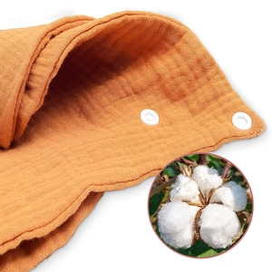 Orange muslin cotton baby bandana bib with soft crinkle texture and snap button fasteners