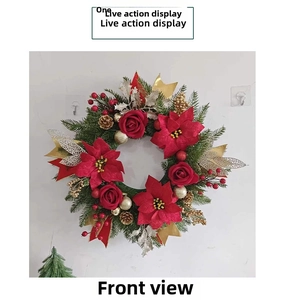 Detail showing artificial red roses, pine cones, and berries on a Christmas wreath