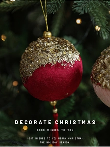Close-up of deep red velvet Christmas ornament with gold sequins and tassel on tree