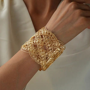 Detail of wide gold plated mesh cuff bracelet with architectural woven wire design