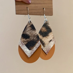 Detail view of triple-layered leopard print and metallic textured teardrop earrings