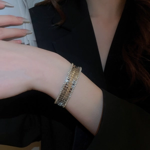 Macro view of gold multi-layer wide cuff bracelet with zircon scales and sparkling rhinestones