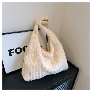 Detail showing the plush faux fur texture and side zipper of this cream tote bag