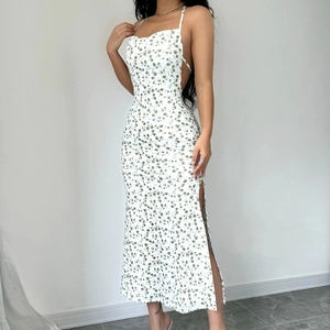 Detailed view of backless floral dress with side slit and elegant white flower pattern