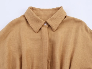 Detailed macro view of the khaki cotton linen shirt collar with neat white button