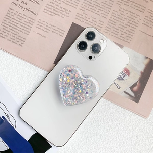Glittery heart-shaped phone griptok with sparkling sequins on a white smartphone