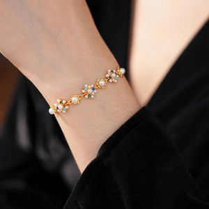Detail of vintage flower bracelet with pearls and colorful gemstones on gold chain