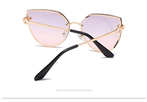 Detail of gold cat-eye sunglasses featuring gradient purple lenses and metal hinges