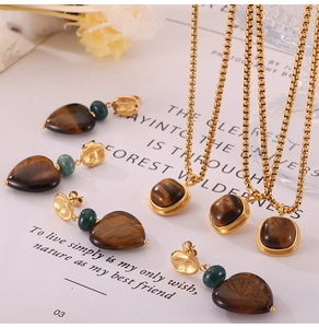 Detail of vintage gold jewelry set featuring tiger eye square pendants and heart earrings