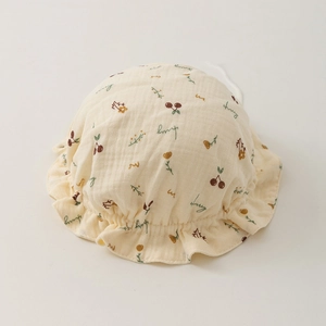 Detail of baby bonnet made of double-layer muslin gauze with cherry floral print and ruffles