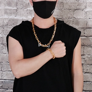Close-up of a 10mm chunky gold curb chain necklace and bracelet set on a male model