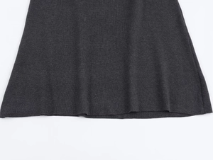 Détail de la maille fine et de l'ourlet d'une robe mi-longue en tricot gris foncé