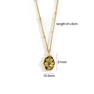 Detail of 14K gold plated necklace with starburst engraved oval lava pendant and green zircon