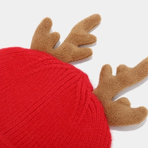 Detail of red cable knit hat featuring brown plush reindeer antlers for festive winter warmth