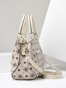 Detailed close-up of beige patterned tote bag with top handles and detachable strap