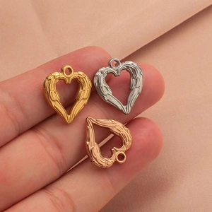 Detailed close-up of heart-shaped angel wing pendants in gold, silver and rose gold