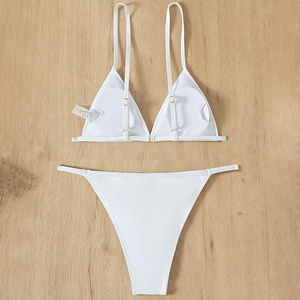 White two-piece triangle bikini with adjustable straps and high-cut bottoms on wood