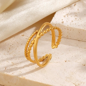 Minimalist gold multi-layer beaded open ring on a marble stone and white silk background