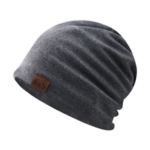 Detail of dark grey cotton beanie showing the knitted texture and brown leather label