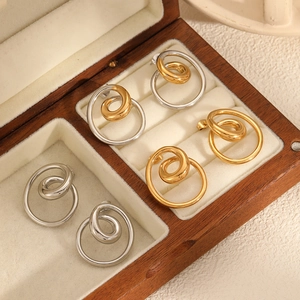 Spiral geometric stainless steel stud earrings in gold and silver set on a jewelry box