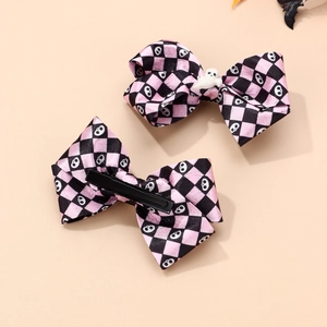 Detail view showing metal duckbill clips on back of pink and black Halloween hair bows