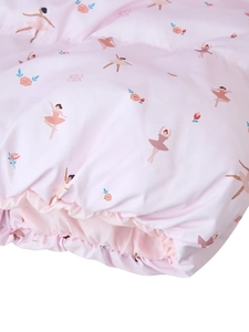 Detail of pink bedding featuring ballerina and floral prints with delicate ruffle edges