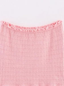 Detailed macro shot of pink waffle knit fabric with decorative ruffle edge detail