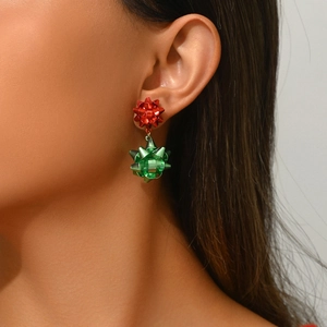 Christmas bow stud earrings in red and green alloy finish worn by a fashion model