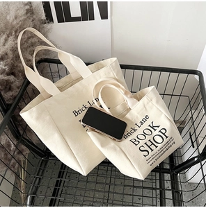 Detailed view of beige canvas tote bags in a metal basket with a lifestyle setting