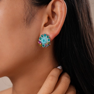 Close-up of luxury flower-shaped earrings with blue crystals and iridescent stones