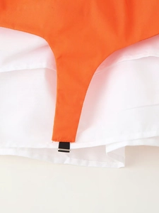 Détail de l'entrejambe du body orange montrant les fermoirs à pression noirs