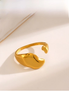 Detailed macro shot of a golden irregular liquid metal ring with high polish finish