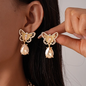 Detailed macro view of vintage butterfly drop earrings with pearls and crystals in gold