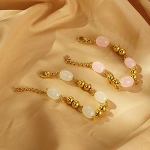 Elegant gold beaded bracelets with opal stones on a luxurious champagne silk fabric background