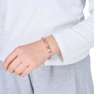 6mm pink zebra stone beaded bracelet with gold accents worn by a model in lifestyle shot