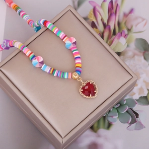 Bohemian style necklace with multi-color beads and a red heart pendant on gold chain