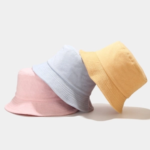 Minimalist soft towel fabric bucket hats in pink, light blue, and pale yellow colors