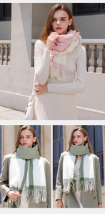 Detail of pink and green contrast plaid scarf featuring soft tassels and warm wool-like texture