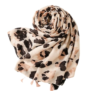 Sciarpa leopardata con nappe e finitura in polvere dorata su sfondo bianco