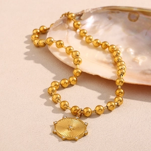 Dettaglio di una collana di perline placcata oro 18K con ciondolo a stella su conchiglia