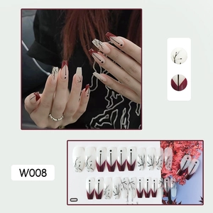 Detailed view of model wearing W008 red and white press-on nails with branch patterns