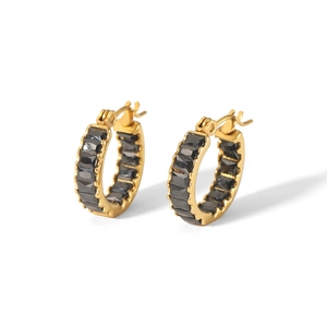 Macro detail of gold-plated hoop earrings with channel-set black rectangular zircons